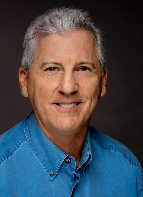 Marco Perella smiling in a headshot.